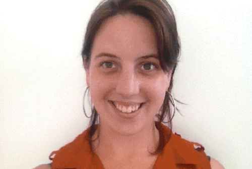 A white woman with brown hair smiles into camera